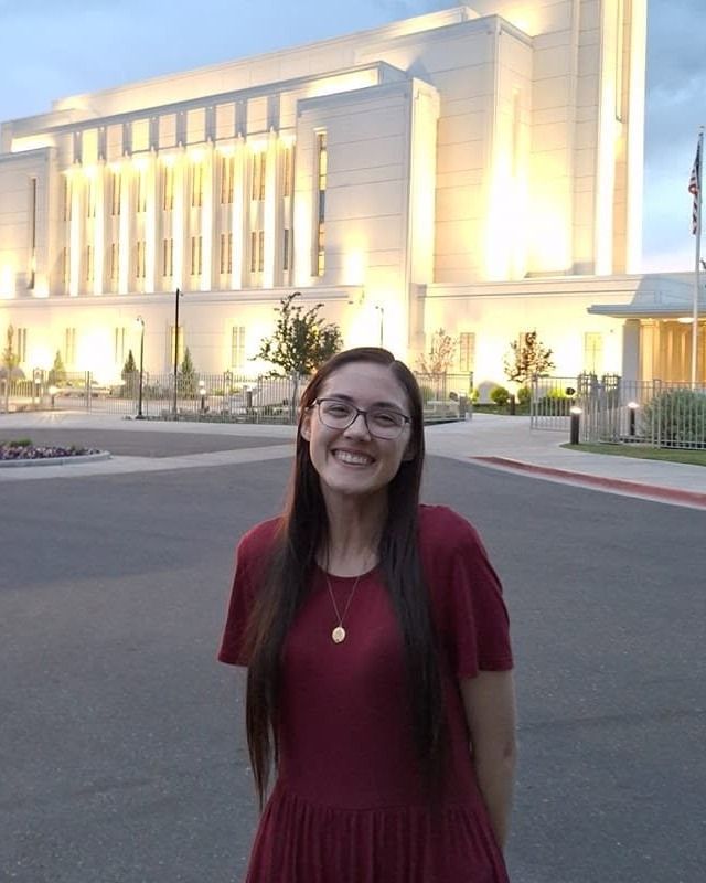 Rachel smiling in front of a temple glowing at dusk